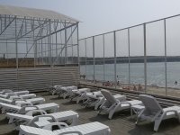 Шезлонги с видом на море, за ветрозащитным экраном